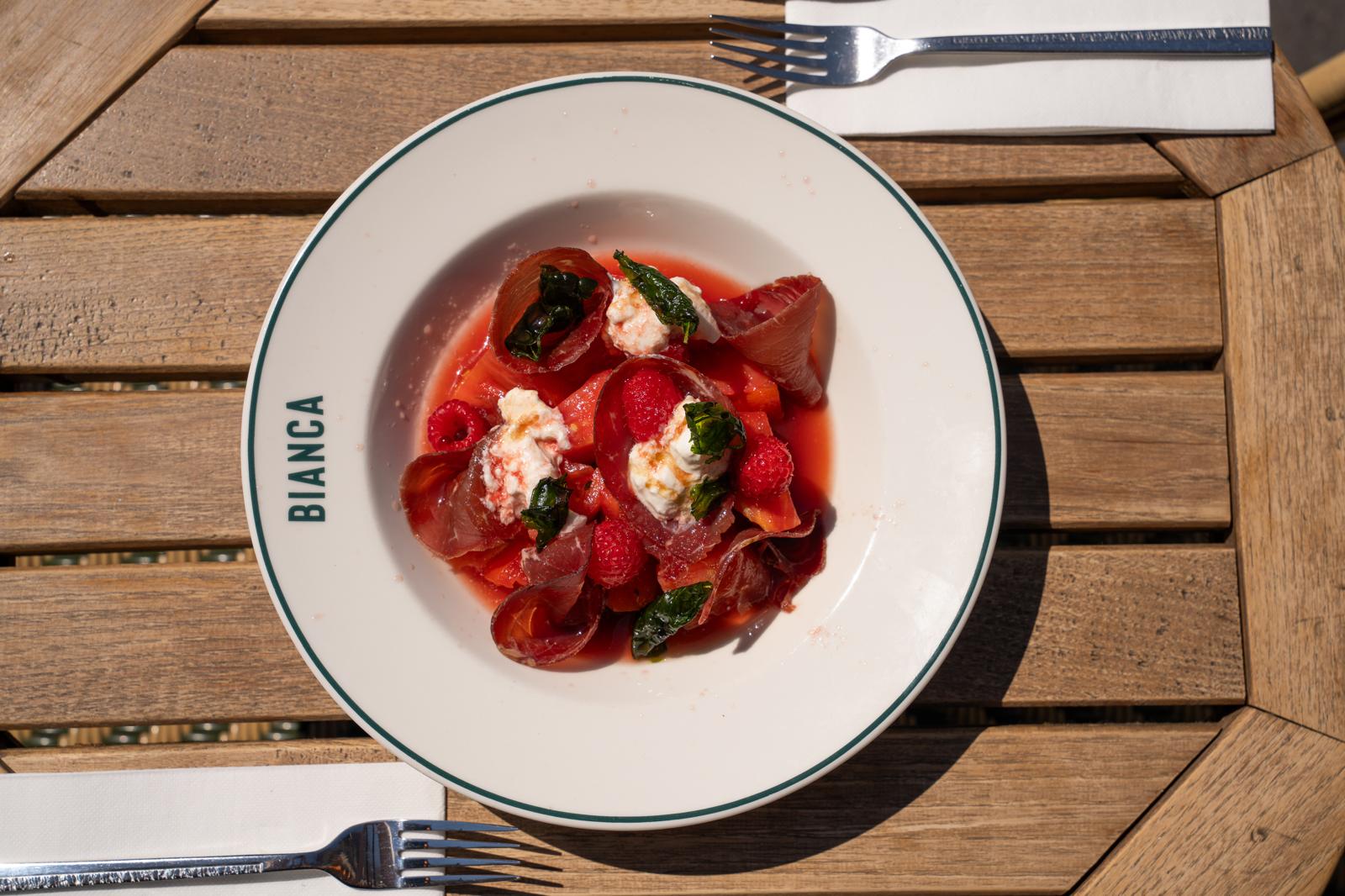 Assiette de jambon cru, melon et framboises
